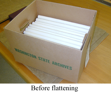 Papers in box with label "Washington State Archives" and caption "Before flattening"